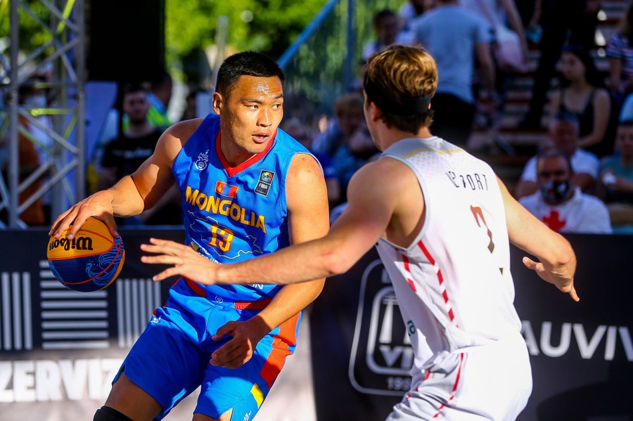 Two men face off during a basketball match.