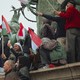A crowd of young people at a Peter Magyar rally holding Hungarian flags