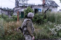 A Ukrainian soldier walks through the ruins of a village on the frontline in Lugansk oblast, Ukraine