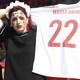 An Iran fan holds a jersey in quiet protest at the November 25 World Cup match between Iran and Wales