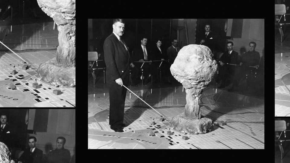 The commandant of the Civil Defence Technical Training Centre in Quebec demonstrates the effect of an atomic bomb exploding over a city in 1952.
