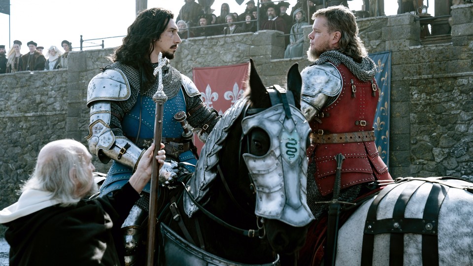 Adam Driver and Matt Damon are seen in armor, on horseback, staring each other down