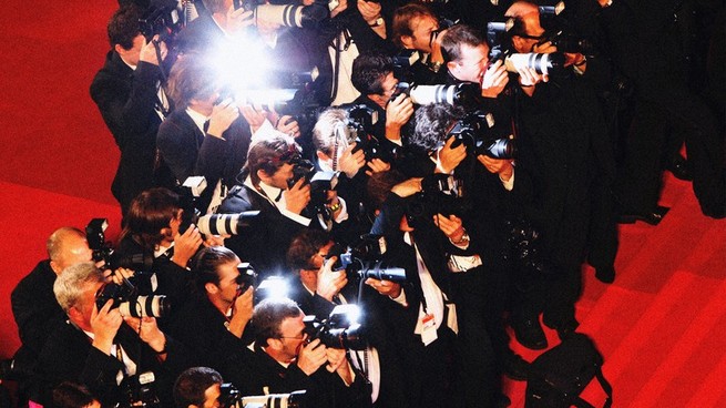 A gaggle of photographers on a red carpet