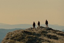 Silhouettes of three Sasquatches on a mountain
