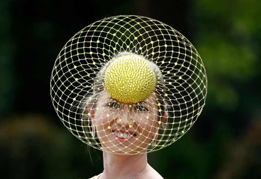 A person is photographed wearing an extravagant hat.