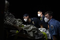 Paramedics prepare to transport a coronavirus patient to the hospital.