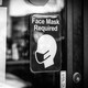 Signs requiring face masks and COVID-19 protocols on a restaurant window in Plymouth, Michigan