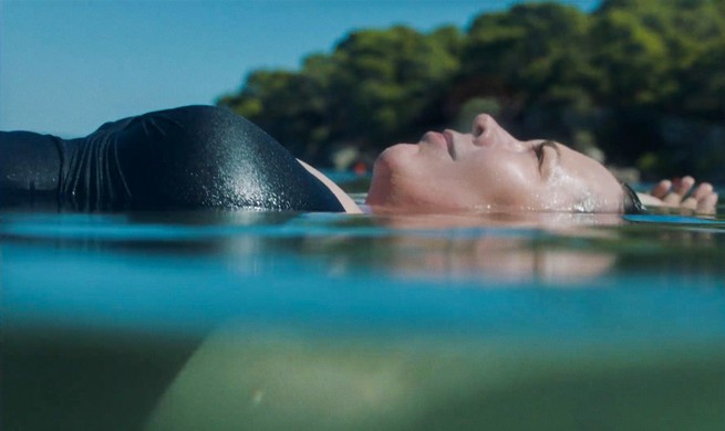 still of Leda floating on water in "The Lost Daughter"