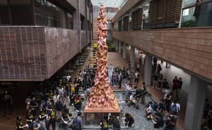 An art installation showing a pillar made of human bodies.