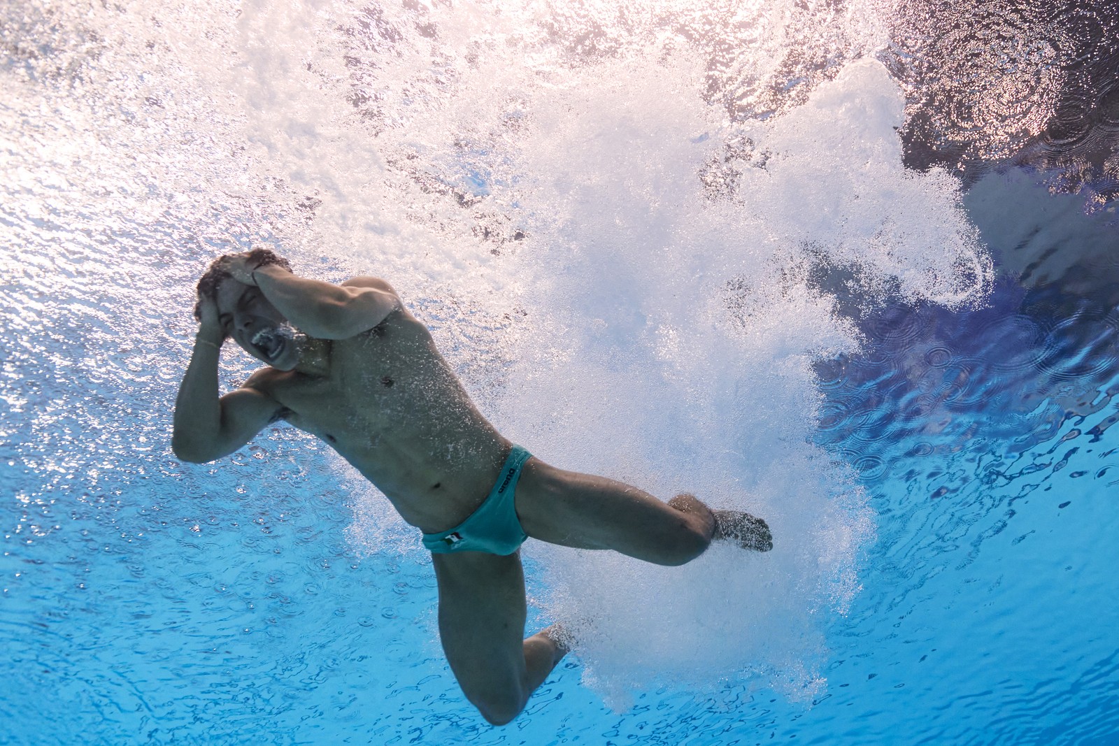 A diver reacts underwater after performing a dive.