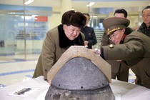 North Korean leader Kim Jong Un looks at a rocket warhead tip after a simulated test of atmospheric re-entry of a ballistic missile