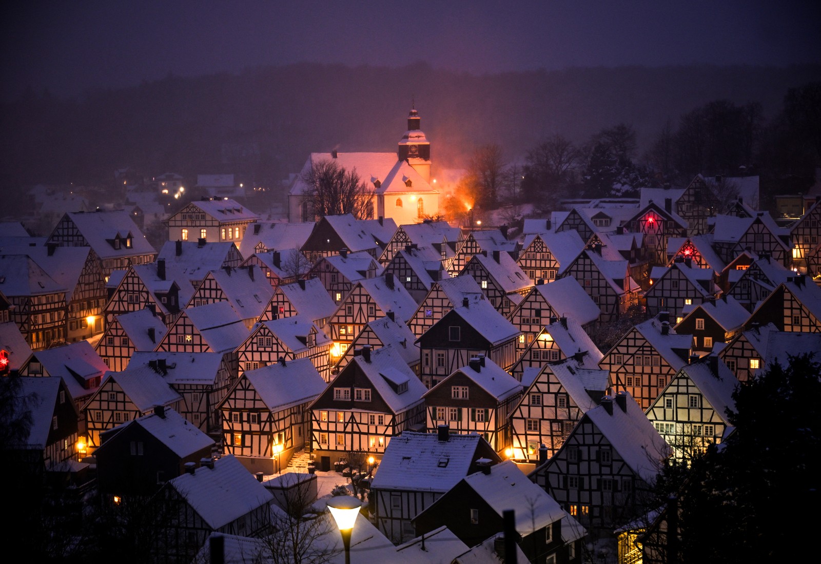 A winter nighttime view of a neighborhood of half-timbered houses in Germany