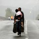 A Syrian refugee carries his daughter in Greece as he approaches the Greek-Macedonian border in September 2015.