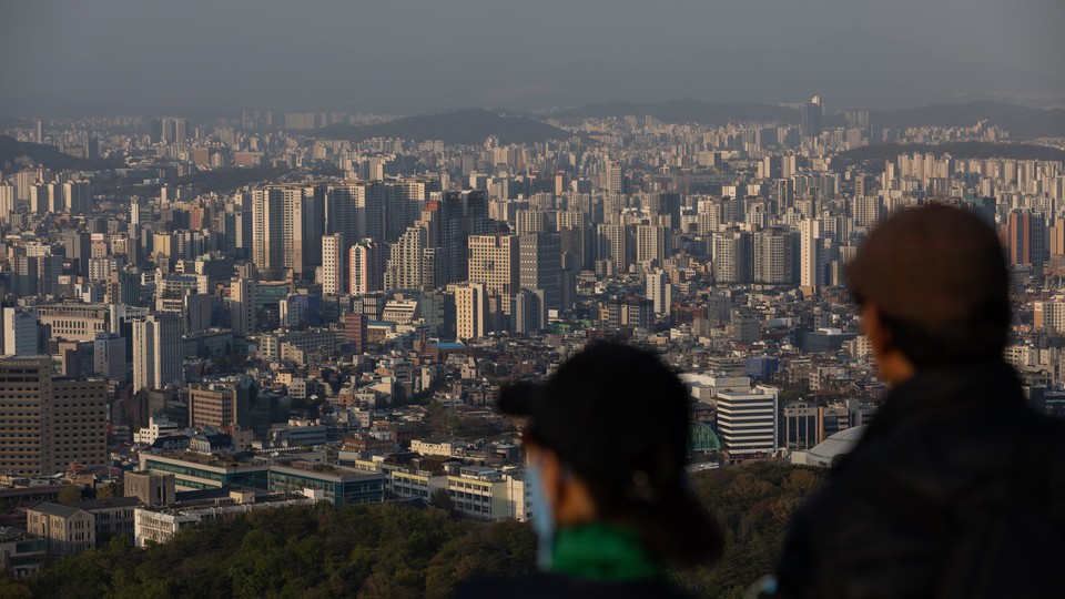 People look out at the city skyline from Mount Namsan in Seoul, South Korea