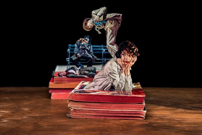 A woman coming out of a stack of books