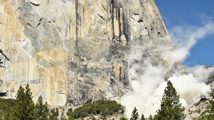 The face of El Capitan with dust rising from the ground