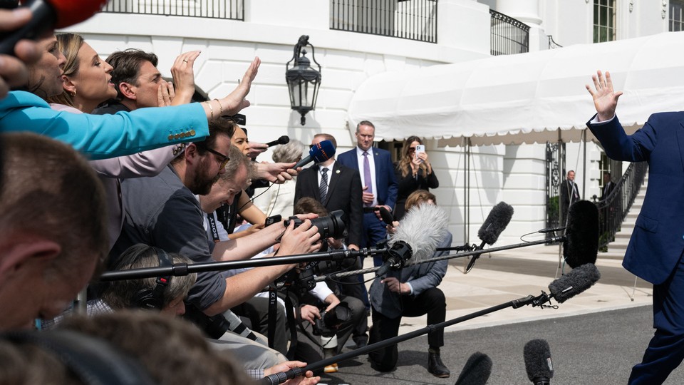 Journalists ask questions of Donald Trump, who waves them off