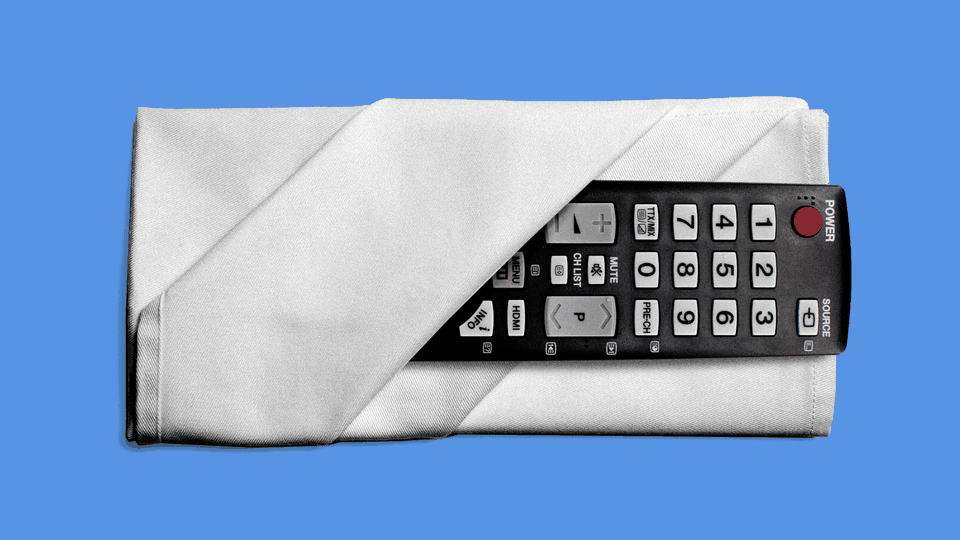 A TV remote folded into a white dinner napkin on a solid blue background