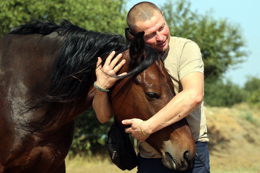 A man embraces a horse.