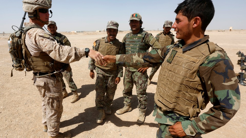 A U.S. Marine shakes hand with Afghan National Army soldiers.