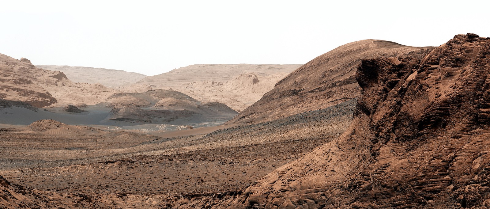 A broad view of a rocky shallow valley on Mars