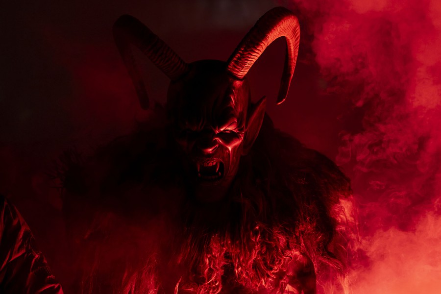 A close view of a person wearing a furry costume and a demon mask with long horns