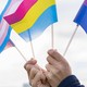Image of hands holding a pride flag, bisexual pride flag, transgender flag, and pansexual flag