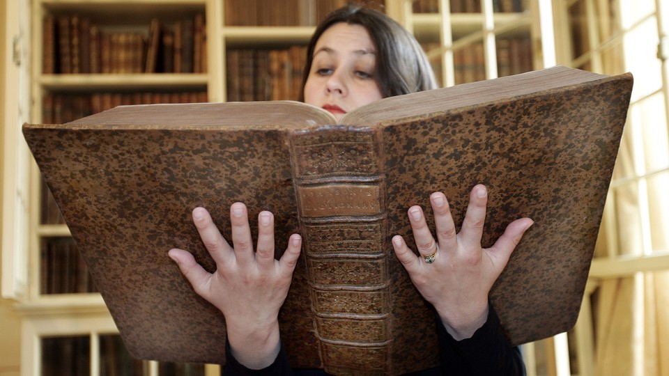 The curator of the museum at Samuel Johnson's house holds a copy of his first dictionary