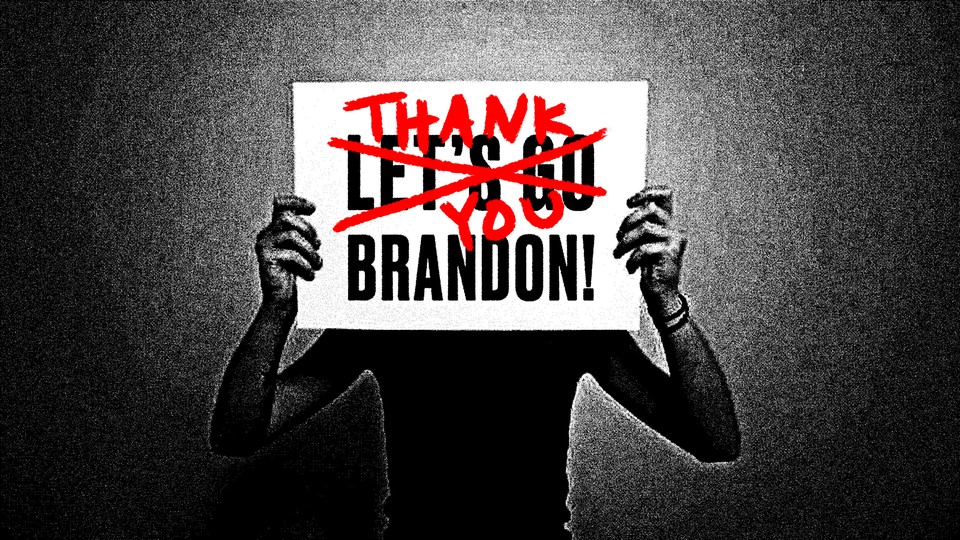 Someone holding a sign that says 'LET'S GO BRANDON,' with 'LET'S GO' crossed out and replaced by 'THANK YOU'