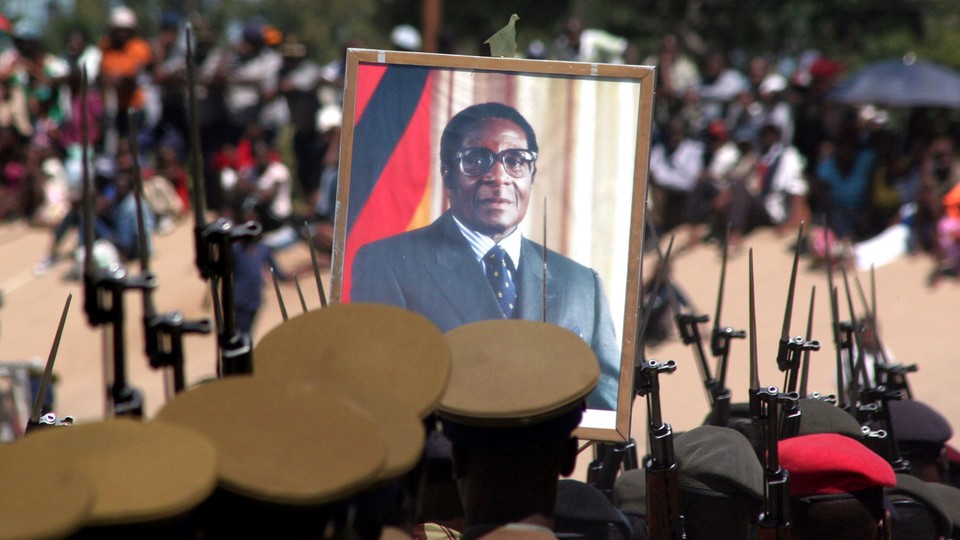 A portrait of Robert Mugabe is held up by Zimbabwean soldiers.