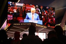 Rallygoers watch Donald Trump.