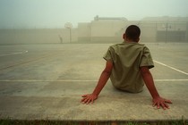 A boy sits in an outdoor recreation area at the Liberty County Jail in Texas.