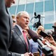 Jeff Sessions surrounded by press, some of whom are carrying microphones and video cameras.