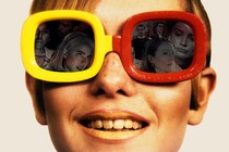 A young woman wearing yellow-red sunglasses reflecting movie characters