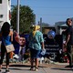 Photograph of people standing at a makeshift memorial for Charlie Kirk outside the Turning Point USA headquarters in Scottsdale, Arizona