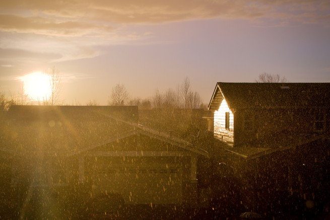 The sun shines through a downpour in a subdivision