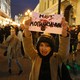 A protester holds a hand-written sign that reads "No 'burialization'" in Russian.