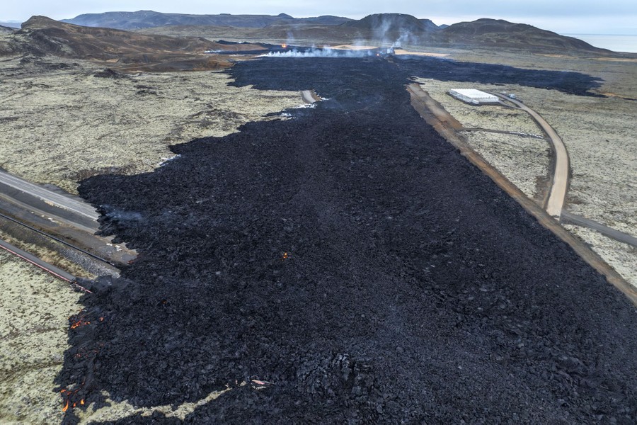 An aerial view of the dark rocks of a cooling lava field
