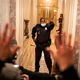 Foto del agente de policía del Capitolio Eugene Goodman parado en la entrada de las escaleras del edificio del Capitolio el 6 de enero de 2021, con la mano levantada, frente a una multitud de alborotadores.
