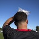 A soccer player holding a bag of ice to his head.