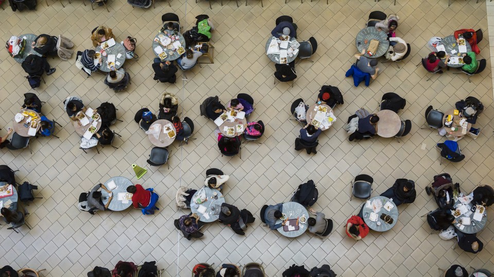 Patrons of a shopping mall sit at tables to eat