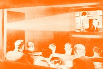 A vintage photo of people watching the projection of a movie in a theater