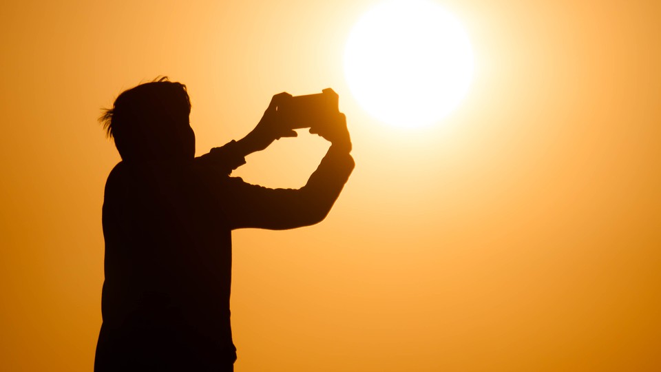 Silhouette of person taking picture with phone