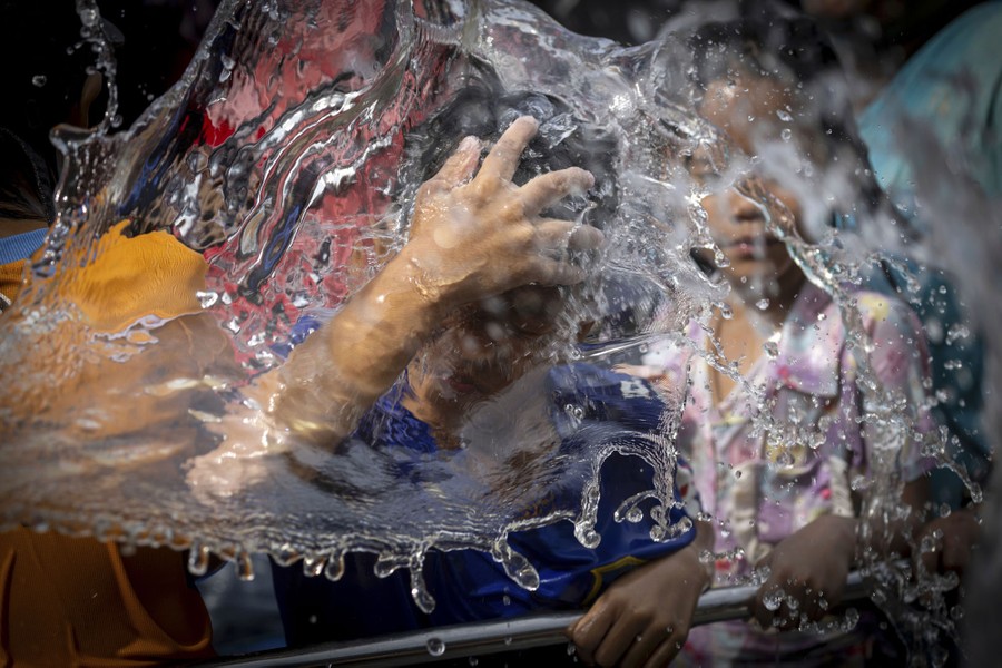 A man reacts as a big splash of water falls on his head.