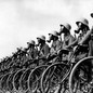A line of German soldiers wearing gas masks and standing beside their bicycles