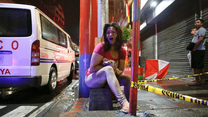 A woman cries after her husband was shot dead by unidentified gunmen riding motorcycles in Manila.