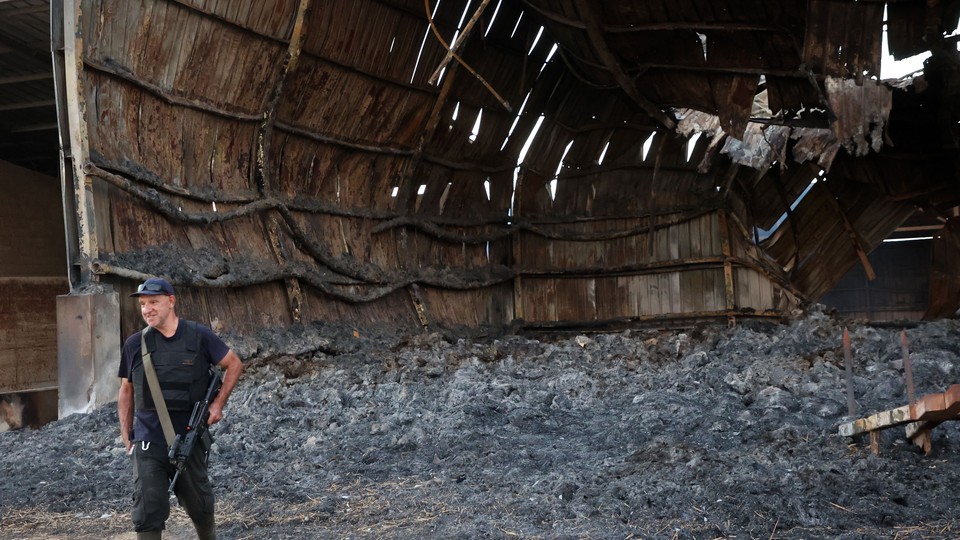 a man with a gun stands among rubble