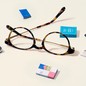 A pair of glasses with tiny books surrounding them