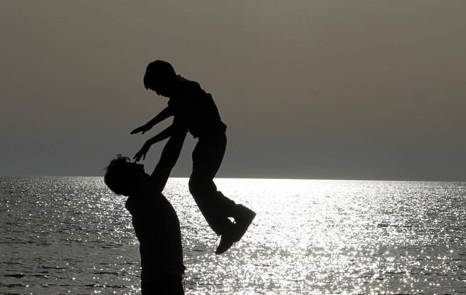 a parent and child playing at the beach