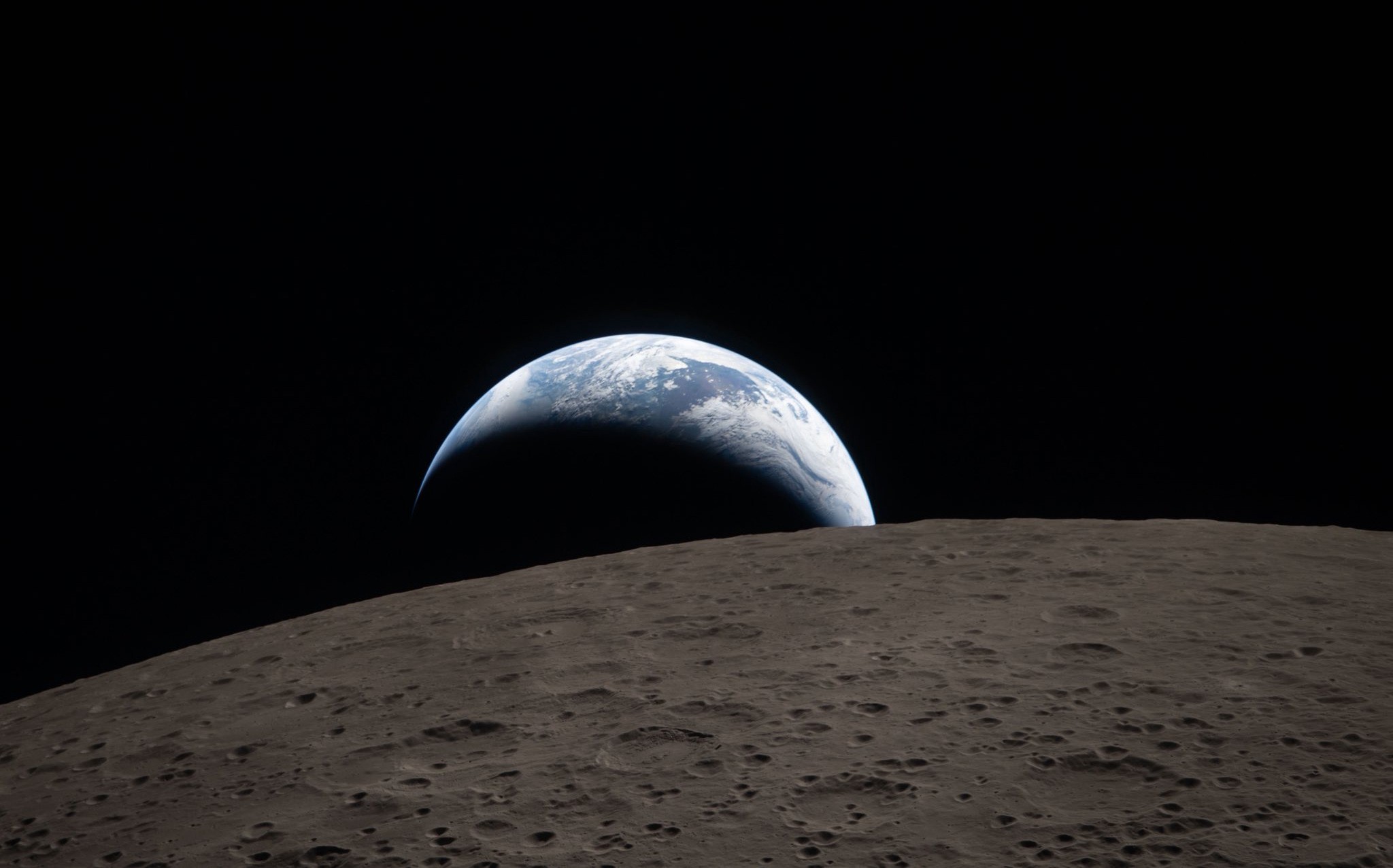 Earth sets behind the moon, as seen by the crew of NASA's Artemis II spacecraft as it swung around the far side of the moon.